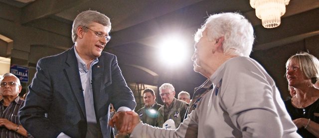 Conservative leader and Canada's PM Harper shakes hands with supporter during a campaign rally in St. Catharines